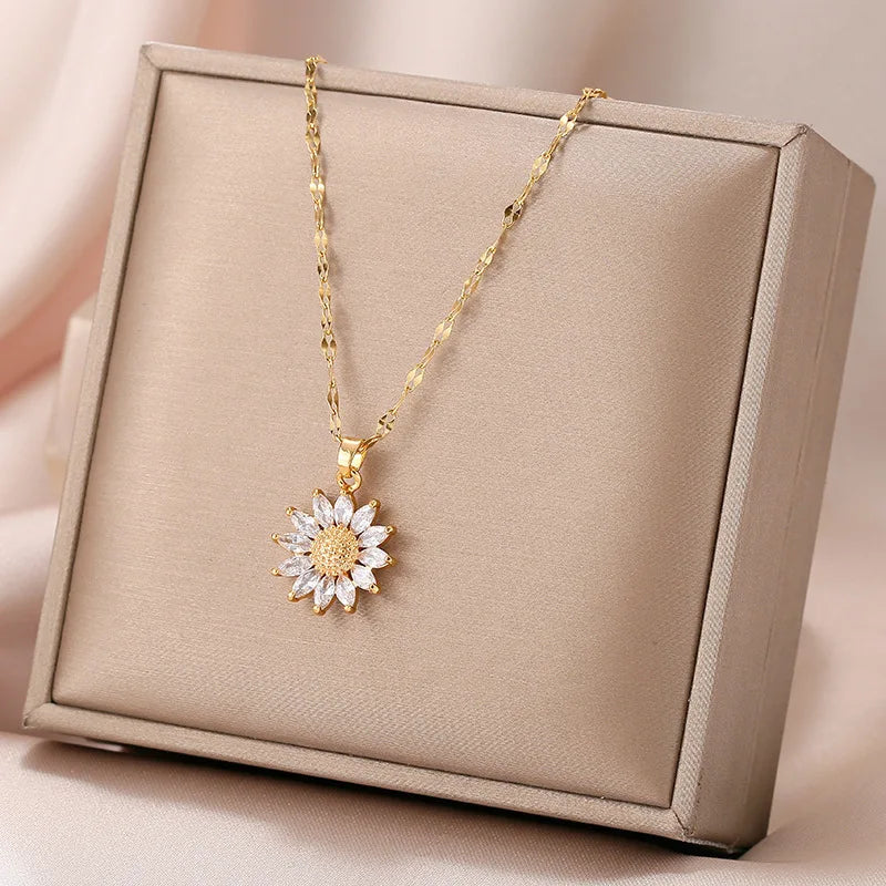 Flat lay of gold sunflower necklace with jewelry props and soft fabric