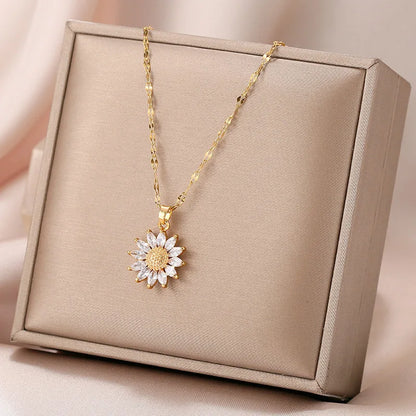 Flat lay of gold sunflower necklace with jewelry props and soft fabric