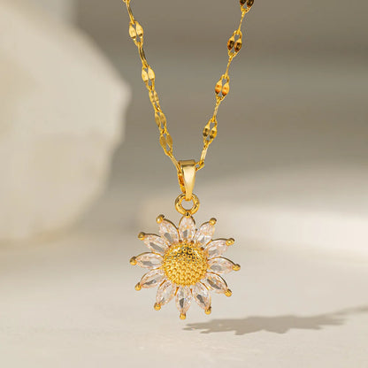 Gold sunflower pendant necklace on neutral background with soft lighting