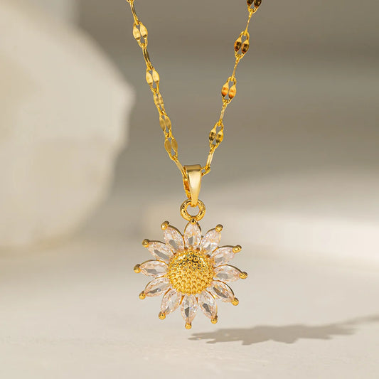 Gold sunflower pendant necklace on neutral background with soft lighting