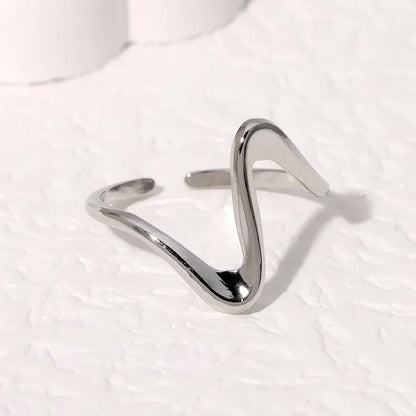 Flat lay of geometric wave ring in both finishes with jewelry props
