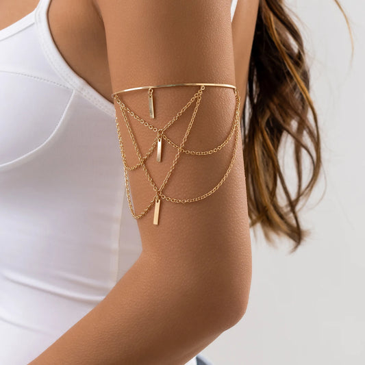 Model wearing gold open bangle on upper arm with sleeveless outfit